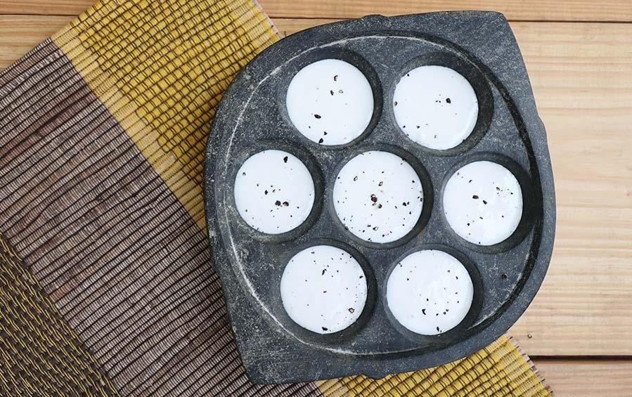 https://www.indicinspirations.com/cdn/shop/products/soapstone-paddu-tawa-7-holes-cookware-687293.jpg?v=1614694848